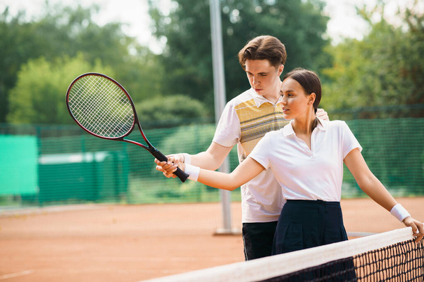 Az edző megtanít teniszezni egy lányt. - Fotó, kép