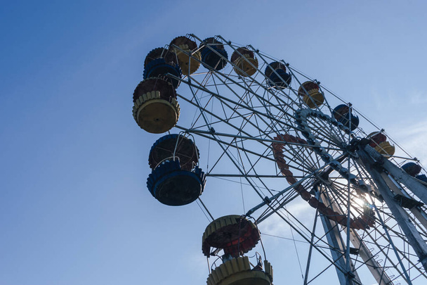 Beautiful retro colorful ferris wheel of the amusement park in the blue sky background - 写真・画像