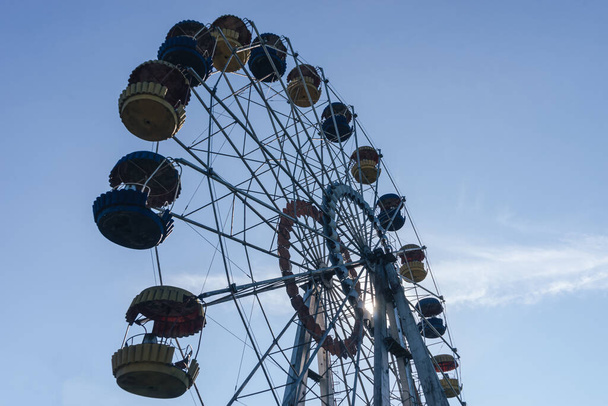 Beautiful retro colorful ferris wheel of the amusement park in the blue sky background - 写真・画像