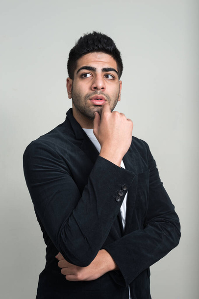 Studio shot of young handsome bearded Indian businessman against white background - Foto, afbeelding
