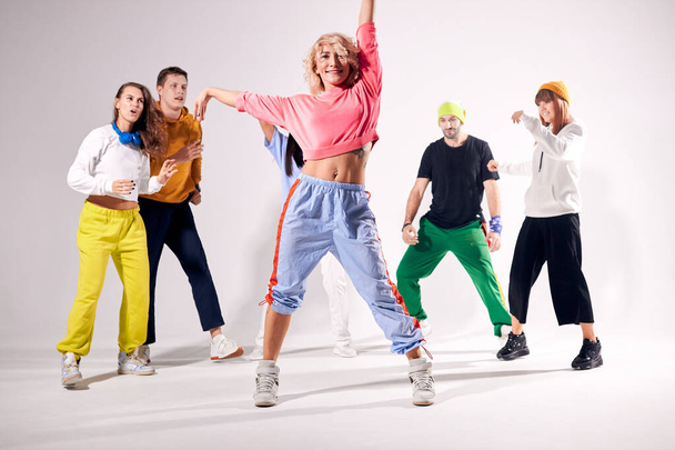 Funny men and women dancing hip-hop at studio - Foto, afbeelding