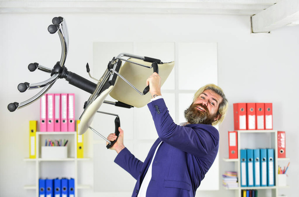Stress concept. Crazy or mad. Furniture sale. Get rid of the excess. Businessman standing in office hold chair. Business man aggressive. Hipster man angry with office chair. Throw out chair - 写真・画像