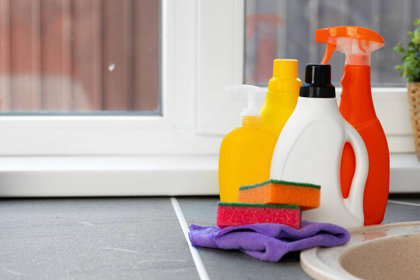 Cleaning detergents and tools on a kitchen counter - Foto, imagen