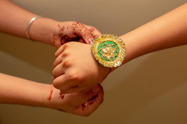 Круп-вид на Дівчину, що прив'язує вузол Ракі до свого брата під час фестивалю в Ракша Бандхан. - Фото, зображення