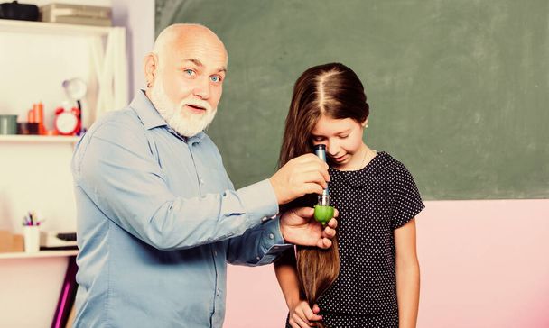 Microscopy. Analysis and synthesis. expand knowledge of world. biological sample. mature teacher look through magnifying glass tube on lime. small girl explore fruit slice. school. science camp - Фото, зображення