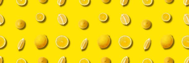the lemon background on yellow with shadows, panoramic citrus image - 写真・画像