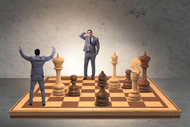 Empresário em grande tabuleiro de xadrez em conceito de estratégia
 - Foto, Imagem