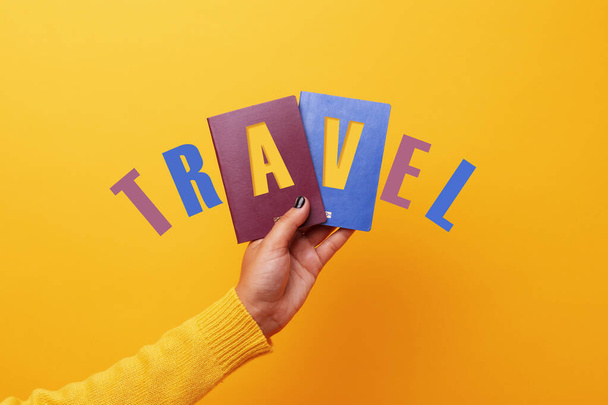 Kézben tartott két útlevél felirattal utazás sárga háttér - Fotó, kép
