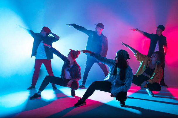 Group of diverse young hip-hop dancers in studio with special lighting effects - Foto, immagini