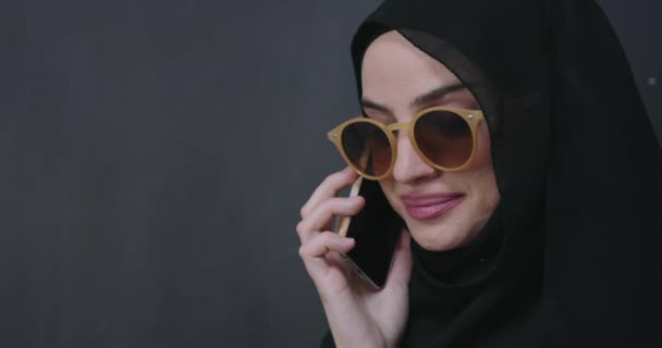 young modern muslim business woman using smartphone wearing hijab clothes in front of black chalkboard - Materiaali, video