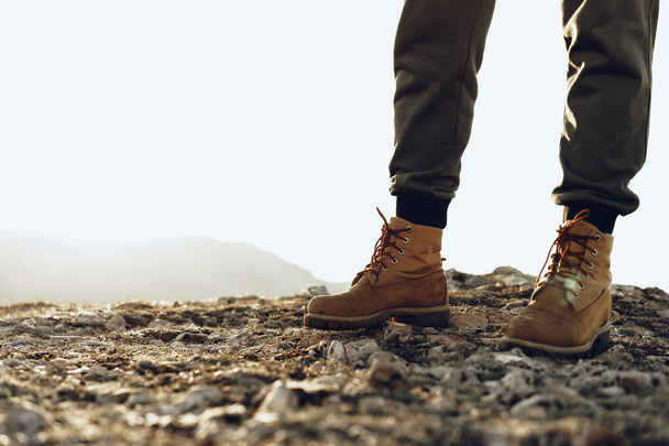 Πόδια ενός backpacker σε μπότες πεζοπορίας στέκεται στην κορυφή του βουνού - Φωτογραφία, εικόνα