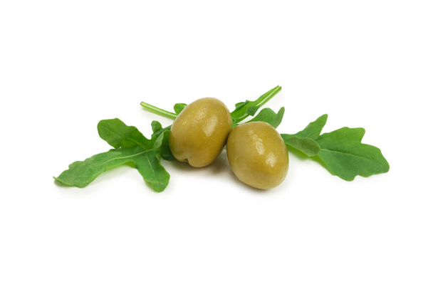 Dwie oliwki, kawałek cytryny i liście rukoli wyizolowane na białym tle.  - Zdjęcie, obraz