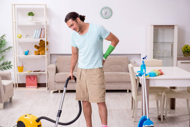 Young injured man cleaning the house - Photo, Image