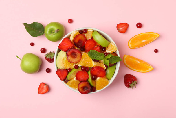 Ensalada de frutas frescas sobre fondo rosa, vista superior
 - Foto, Imagen