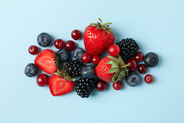 Mix of fresh berries on blue background, top view - Zdjęcie, obraz