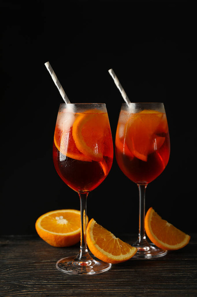 Composition with aperol spritz cocktail against black background - Foto, afbeelding