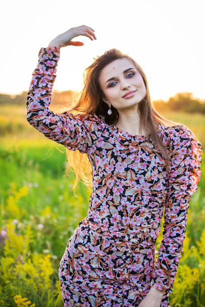 portrait of a beautiful young girl in colored dress, outdoors, in the field - Fotografie, Obrázek