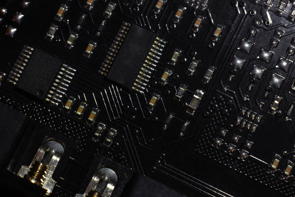 Black motherboard (PCB) digital chip. Technical science background. Integrated communication processor. Information and engineering component. Programming and technology - Foto, Bild