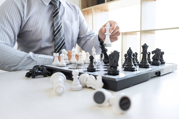 Biznesmen grający w szachy i myśląca strategia o katastrofie obalają przeciwną drużynę i analizują rozwój dla zwycięstwa i sukcesu. - Zdjęcie, obraz