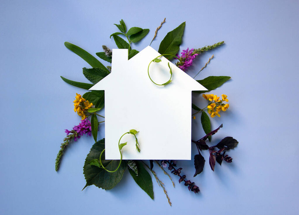 Coronavirus, COVID-19 protection logo with nature background. Shape cut out of paper in the form of a house with natural plants and flowers. Ecology concept. Care of nature. Copy space. - Photo, Image
