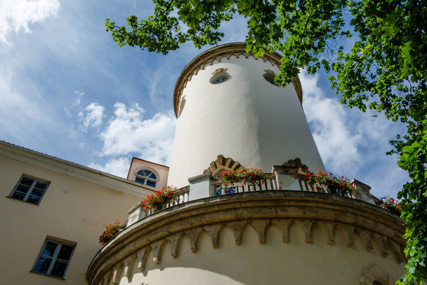 Відновлений середньовічний замок в Кесіс, Латвія. Стара європейська архітектура. Квіти на балконі. Біла вежа. - Фото, зображення