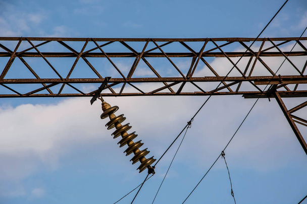 Electrification railway contact. High-voltage power line. Blue cloudy sky. - Photo, Image