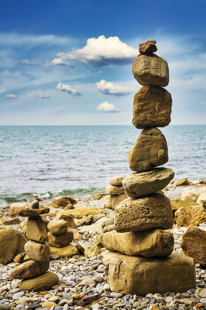 Pyramid of sea stones on the seashore at the pebble beach. Concept of harmony and balance. - Photo, Image