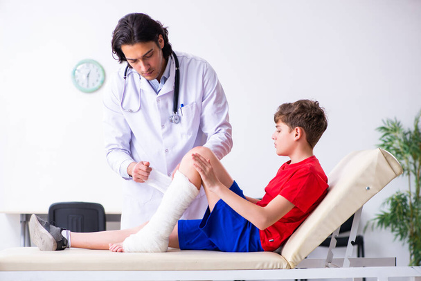 Leg injured boy visiting young doctor traumatologist - Photo, Image