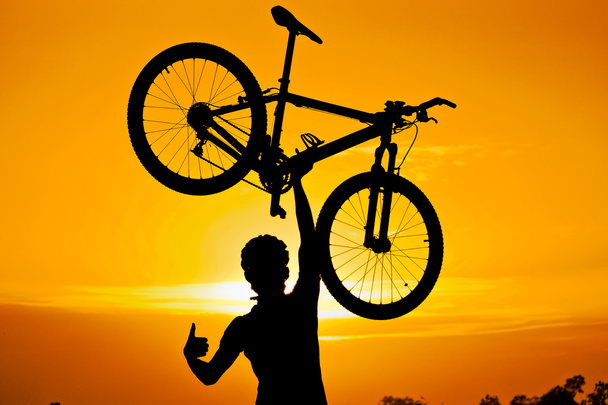 Ciclista levantando su bicicleta de montaña
 - Foto, imagen