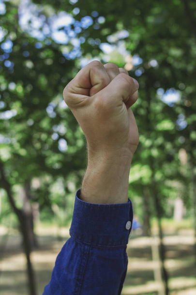 Un tipo con una camisa azul muestra gestos en el parque - Foto, Imagen