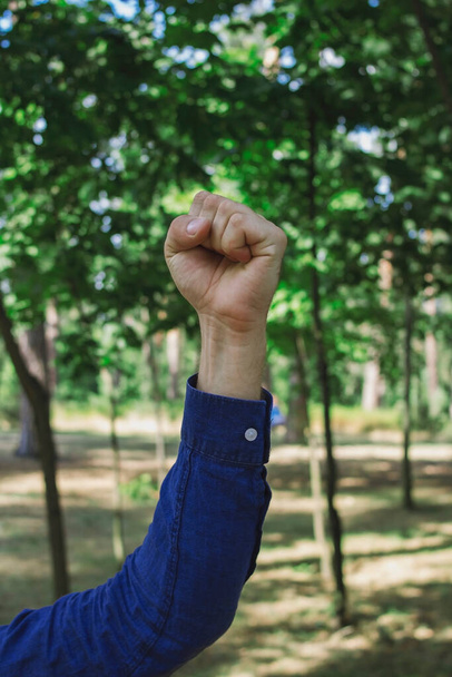 Un tipo con una camisa azul muestra gestos en el parque - Foto, Imagen