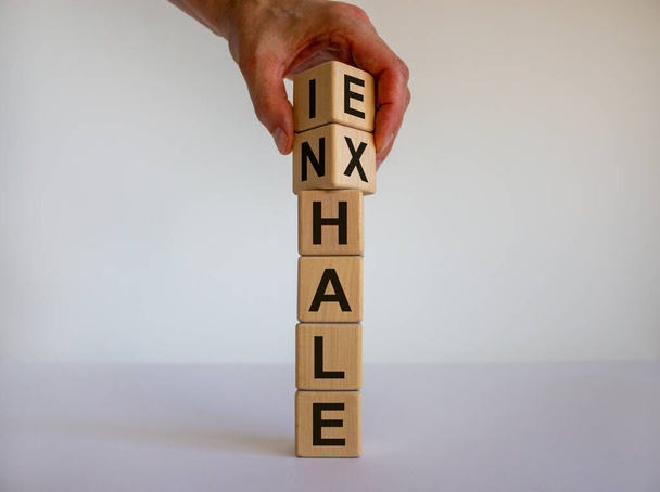 Inhale, Exhale concept. Hand turns cubes and changes the word 'INHALE' to 'EXHALE'. Beautiful white background. Copy space. - Photo, image