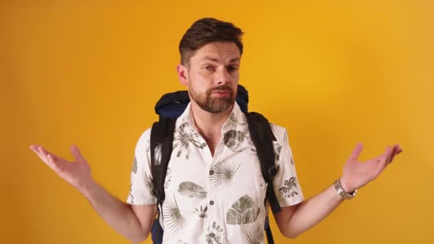 Disappointed face expression on young bearded traveler with backpack isolated - Materiał filmowy, wideo
