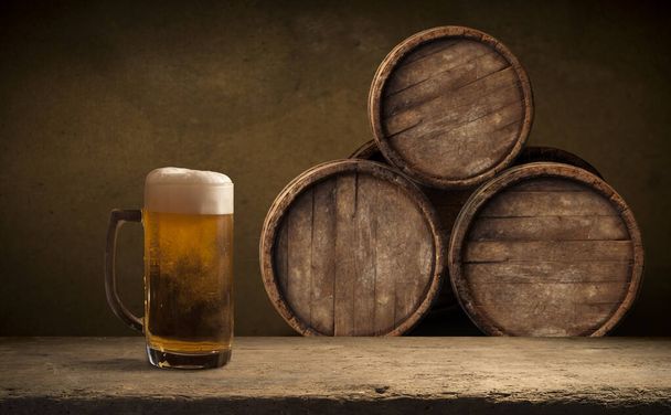 Beer barrel with beer glasses on a wooden table. The dark brown background. - Valokuva, kuva