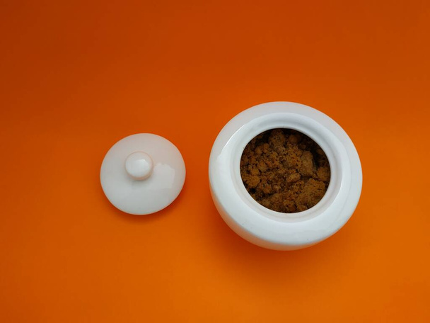 bela tigela de açúcar branco com um fundo laranja
 - Foto, Imagem