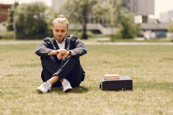Businessman with book sitting in a summer city - Fotografie, Obrázek