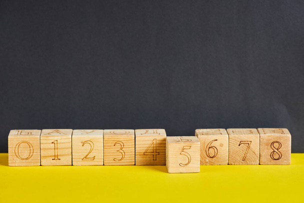 Numbers on wooden cubes in line . The number five is in forward. - Photo, image