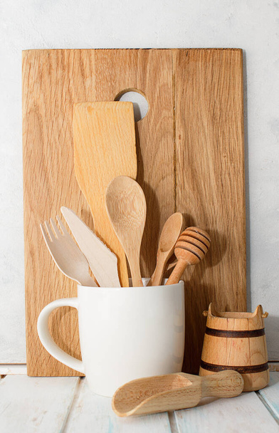 Kitchen wooden spoons for sugar, spices, honey, plate in white cup on gray background wall - Foto, Imagen