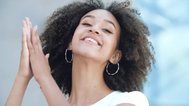 Mooi Afro-Amerikaans meisje klapt in haar handen, glimlacht tand en zegt wow. Jonge vrouw is verrast en gelukkig, spreekt goedkeuring en bewondering uit, applaudisseert. Concept van oprechte emoties en gevoelens. - Video