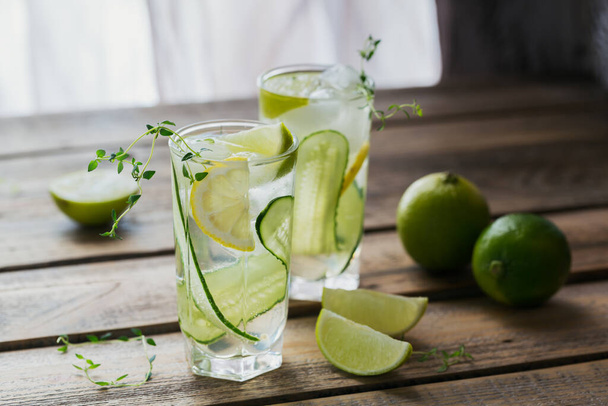 Glass of cucumber soda drink on wooden table. Summer healthy detox infused water, lemonade or cocktail background. Low alcohol, nonalcoholic drinks, super food, vegetarian or healthy diet concept - Photo, Image