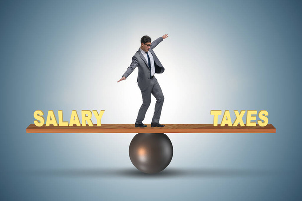 Biznesmen równoważenie między podatkami a wynagrodzeniem - Zdjęcie, obraz