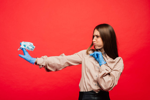 Tıbbi maskeli ve eldivenli duygusal bir kadın. Salgın koronavirüs salgını. Covid-19 karantina kırmızı. - Fotoğraf, Görsel