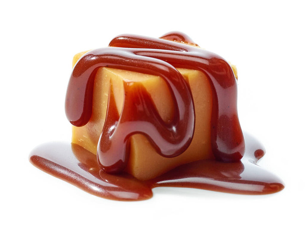 карамельные конфеты с шоколадным соусом на белом фоне - Фото, изображение