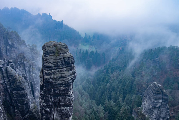 Dark blue  highland scenery within misty weather aerial view. Rocky tower. Soft Sunlight Eco Friendly Environment Concept Drone Flight - Photo, Image