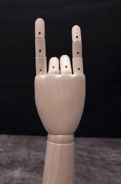 Дерев'яна рука маннекена, що показує знакові роги
 - Фото, зображення