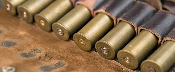 Охотничье ружье с боеприпасами на камуфляжном фоне - Фото, изображение