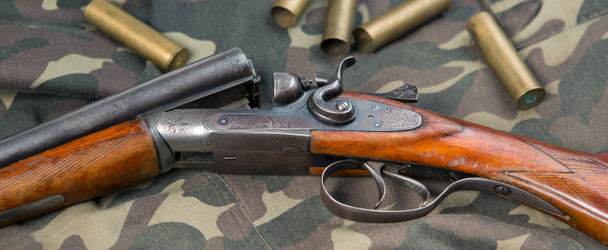 Κυνηγετικό όπλο με πυρομαχικά σε φόντο καμουφλάζ - Φωτογραφία, εικόνα