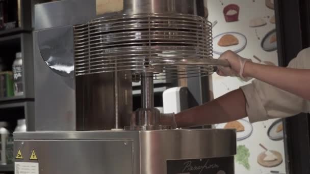 As mãos de um chef em um restaurante de fast food usa uma ferramenta de prensa de pizza para remodelar a massa de uma bola para plana. Press Flow Chart pizza, forno de pizza. Unidade, ferramenta. Máquina de imprensa para fazer pizza
. - Filmagem, Vídeo