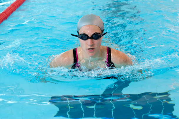 Молода жінка плаває в критому басейні крупним планом. стиль ламання
. - Фото, зображення
