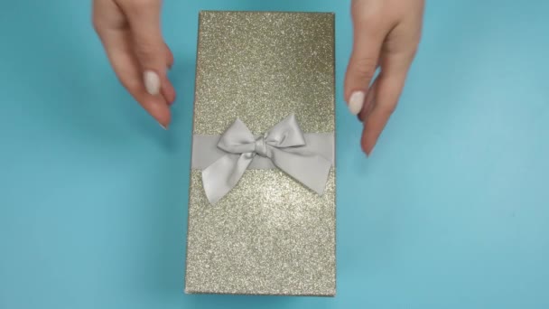 Γυναικείο κουτί δώρου με καλλυντικά μακιγιάζ και αξεσουάρ στο φόντο χρώμα, top view - Πλάνα, βίντεο